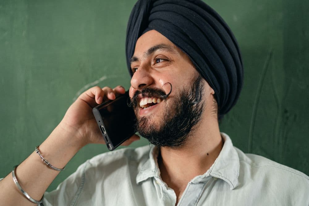 A man smiling while speaking on a mobile phone